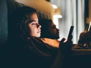 Paar mit Smartphones im Bett